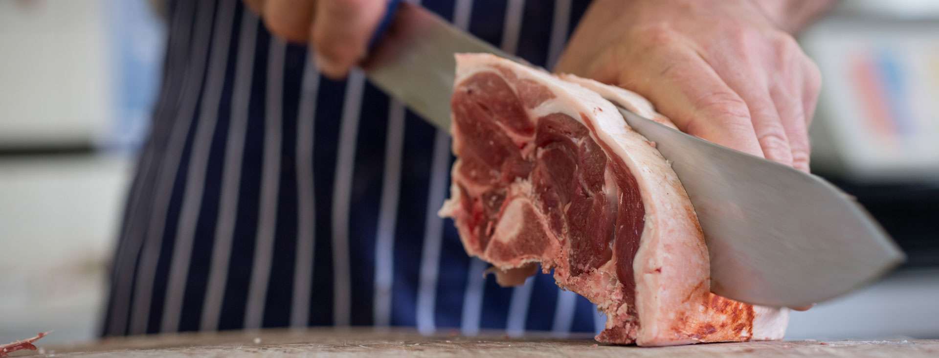 Close up of butcher cutting lamb