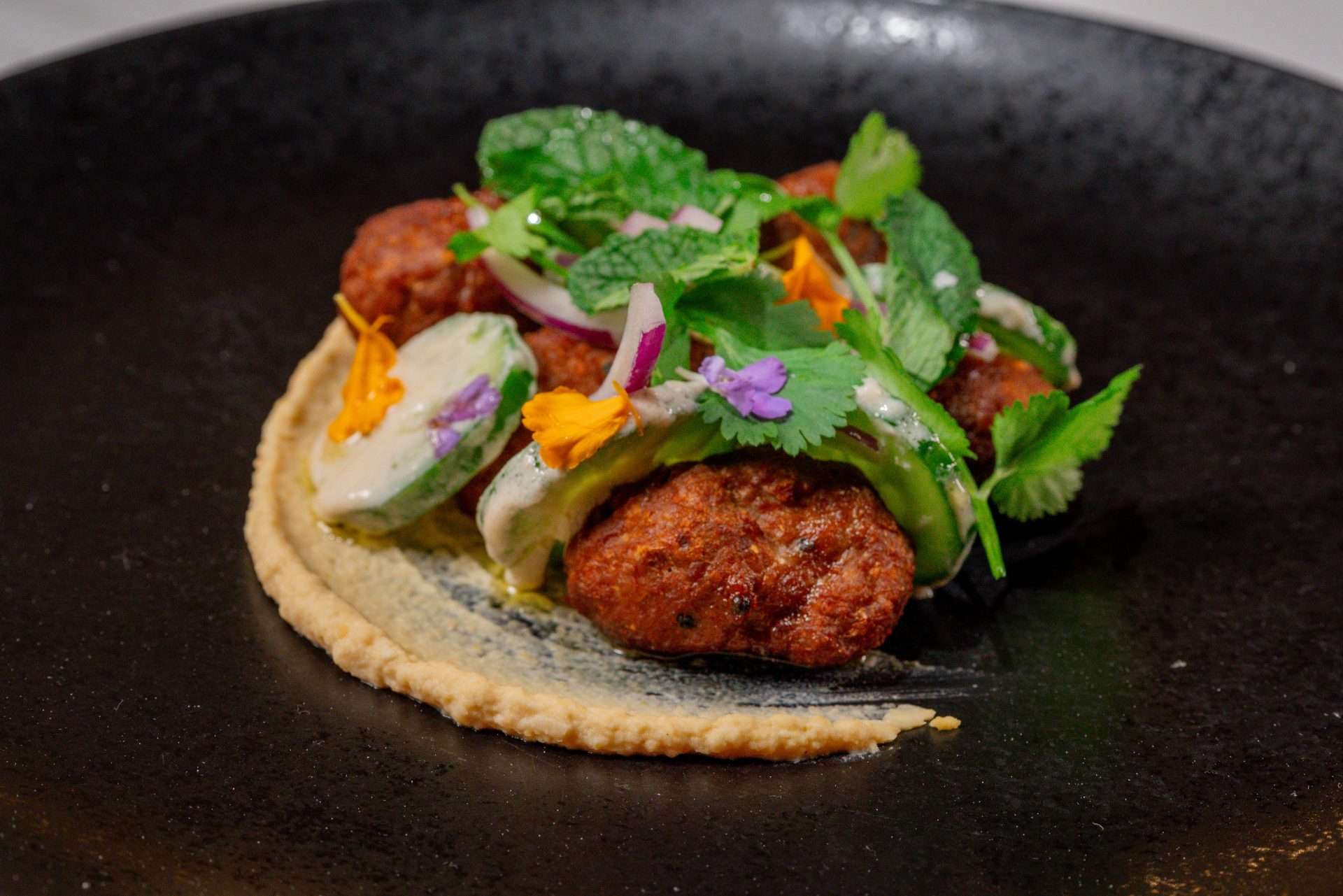 Lamb on plate with hummus