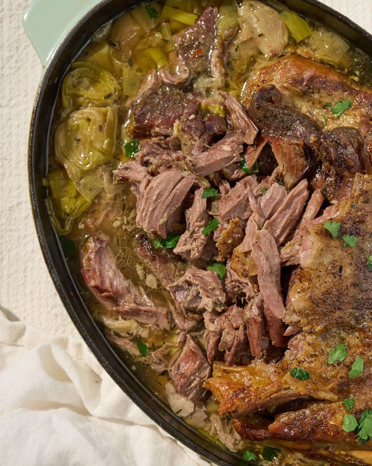 Slow roasted American lamb shoulder served with braised leeks in a white wine broth, topped with tender pulled lamb and fresh herbs.
