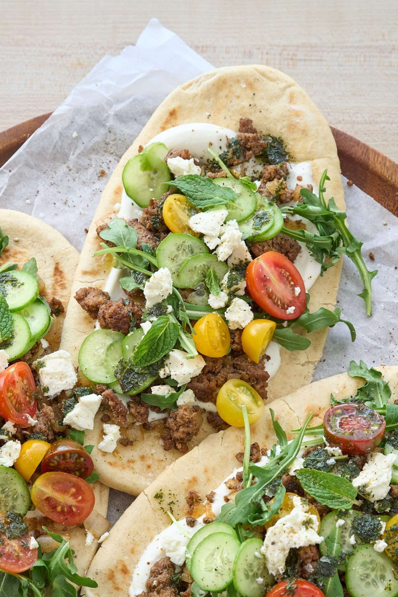 Warm flatbread topped with spiced American lamb, fresh cucumbers, cherry tomatoes, arugula, feta cheese, and a drizzle of mint oil